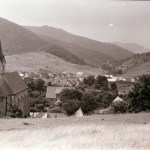 1 Mojtínsky kostol, pohľad na obec a v pozadí tri skalné vráta. Foto Ladislav Makay, 1979 (Archív Vlastivedného múzea v Považskej Bystrici)